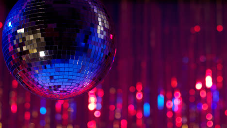 Nahaufnahme-Einer-Spiegelkugel-In-Einem-Nachtclub-Oder-Einer-Disco-Mit-Funkelnden-Lichtern-Im-Hintergrund